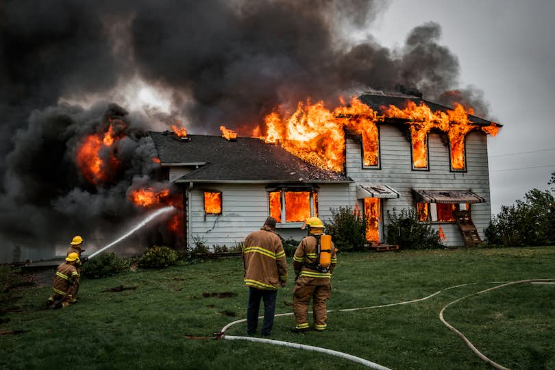 Firefighters in front of burning house