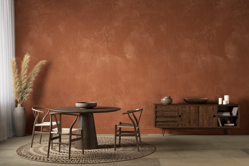 Interior dining room with brightly colored orange plaster wall