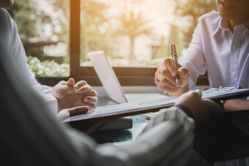 Three people undergoing negotiations at a table. Appraisal contingencies often require negotiations.