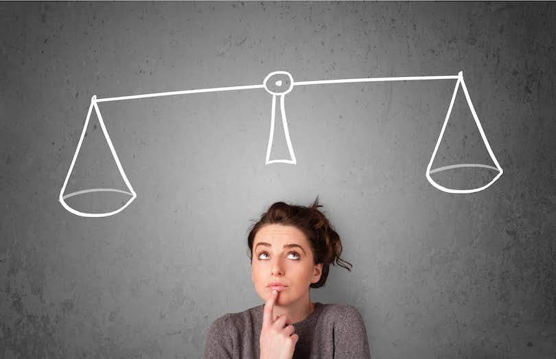 Woman contemplates, with a superimposed balance scale over her.