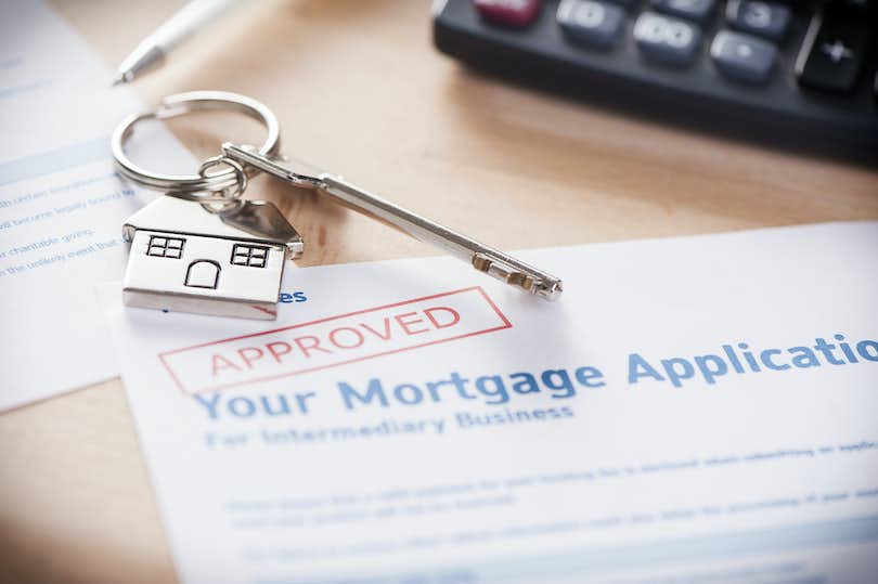 Approved mortgage loan agreement application with house shaped keyring