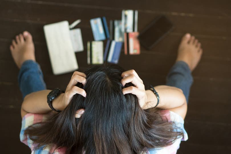 Top view of stressed woman trying to find money to pay credit card debt