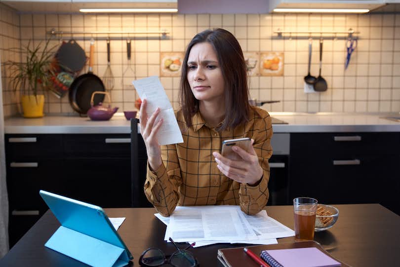 Woman looking at bills trying to figure out 
