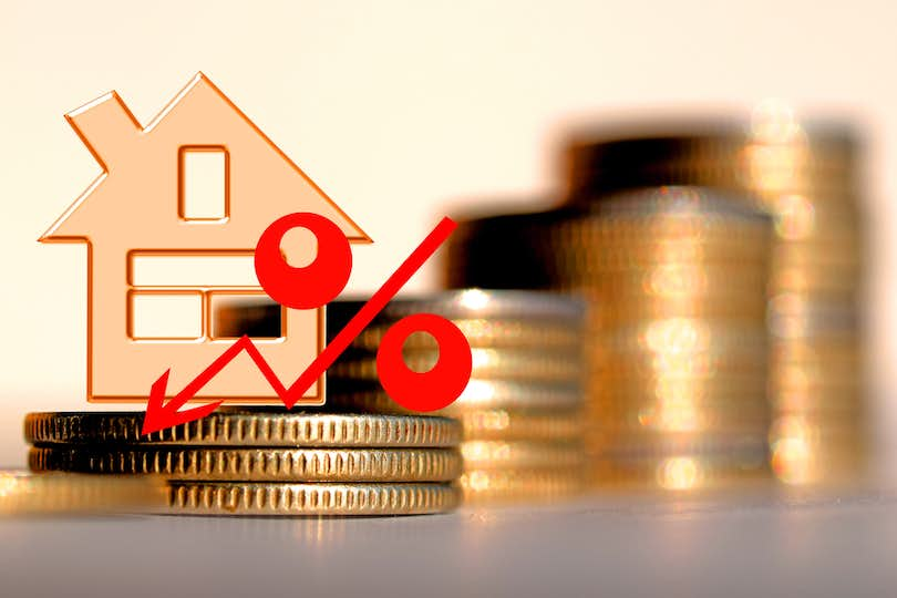 Illustration of percentage sign and down arrow, over coin stacks and house model