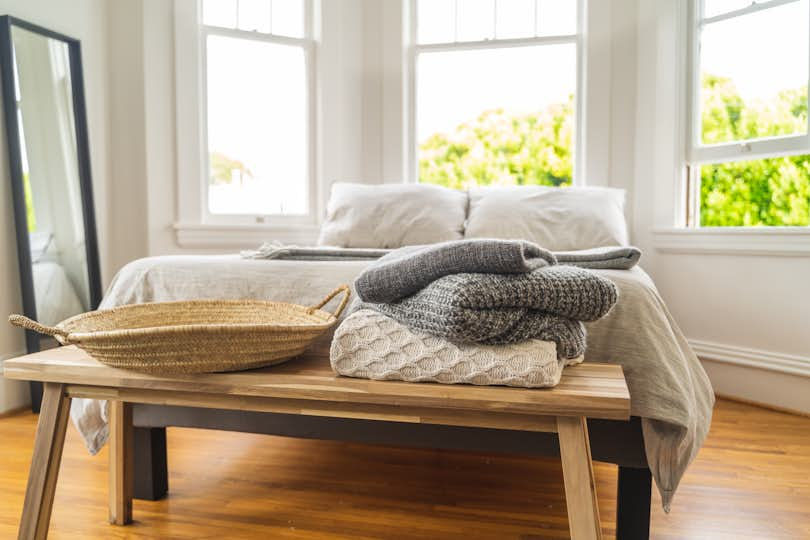 Bright, sun-filled bedroom in an Airbnb property with cozy touches, including blankets and pillows