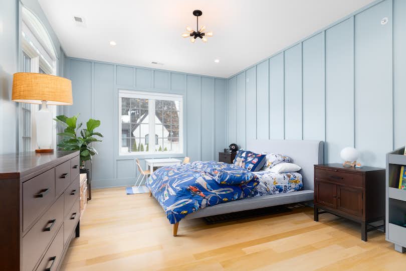 A renovated kids room with blue wainscoting