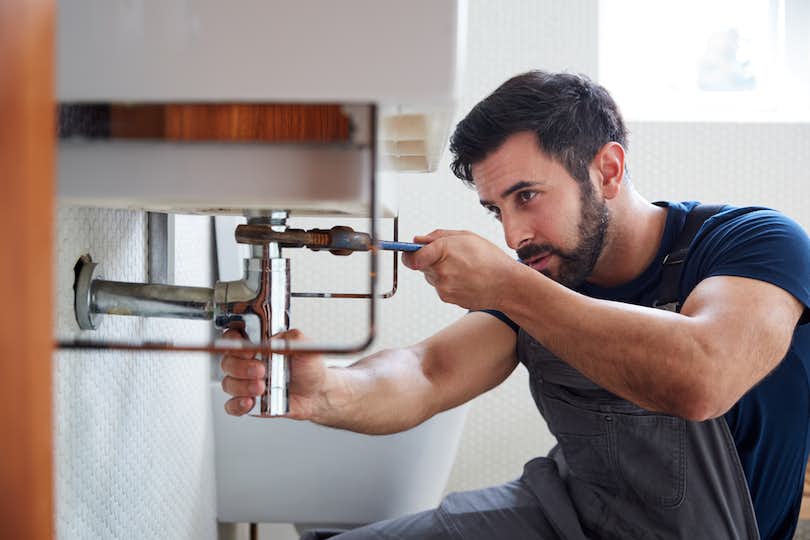 Man repairs a sink in home